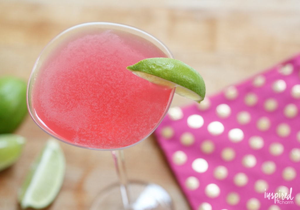 pink cosmo drink with lime garnish