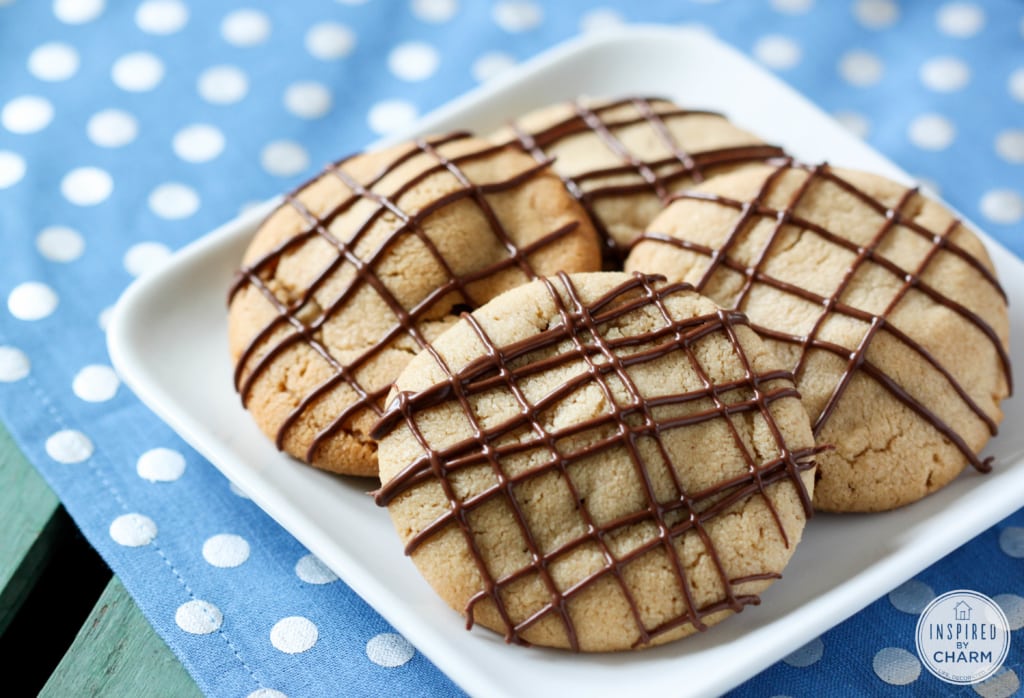four stuffed peanut butter cookies on a white plate.