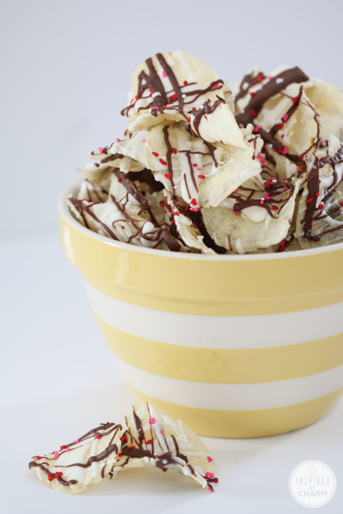 potato chips drizzled with chocolate in yellow stripe bowl.