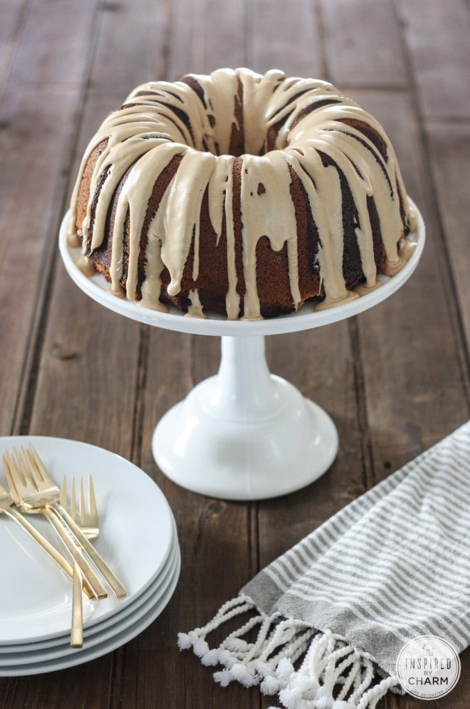 Chocolate Peanut Butter Cake with Peanut Butter Glaze on a cake stand with plates and forks.