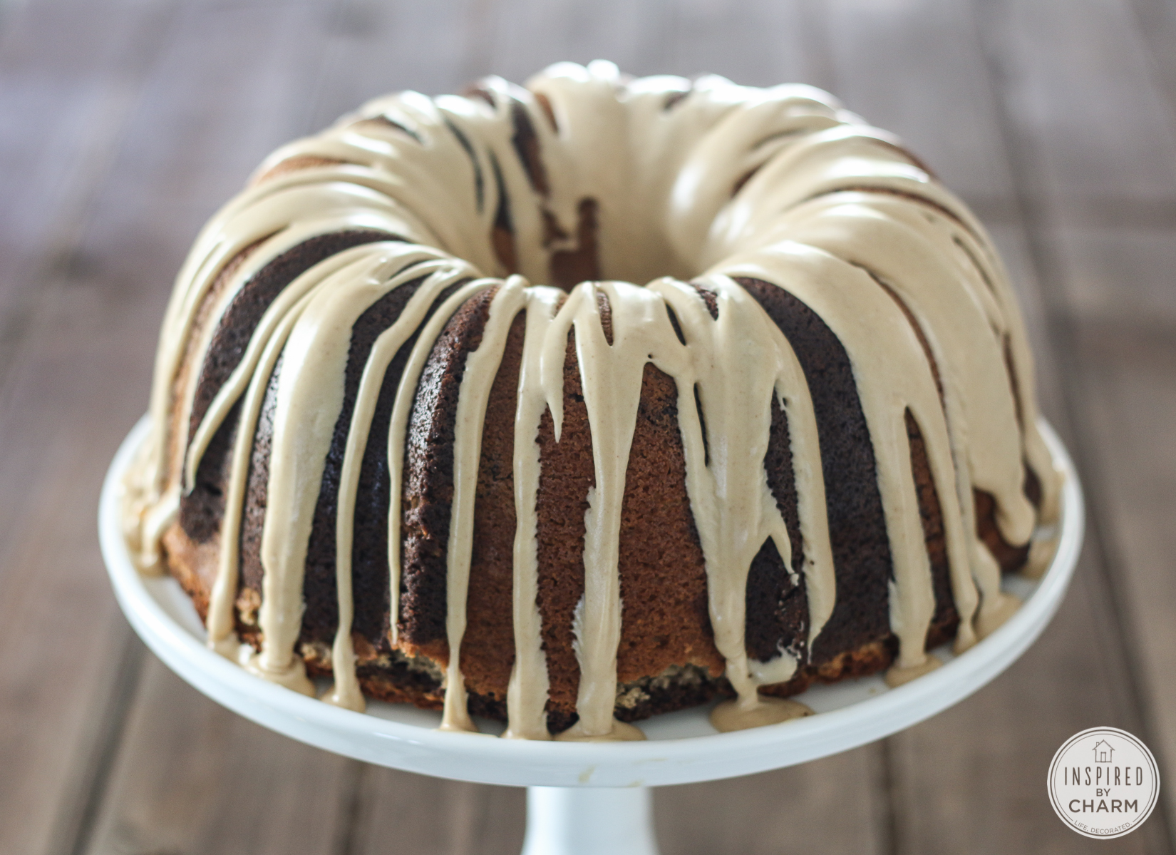 chocolate peanut butter bundt cake served on a white cake stand.