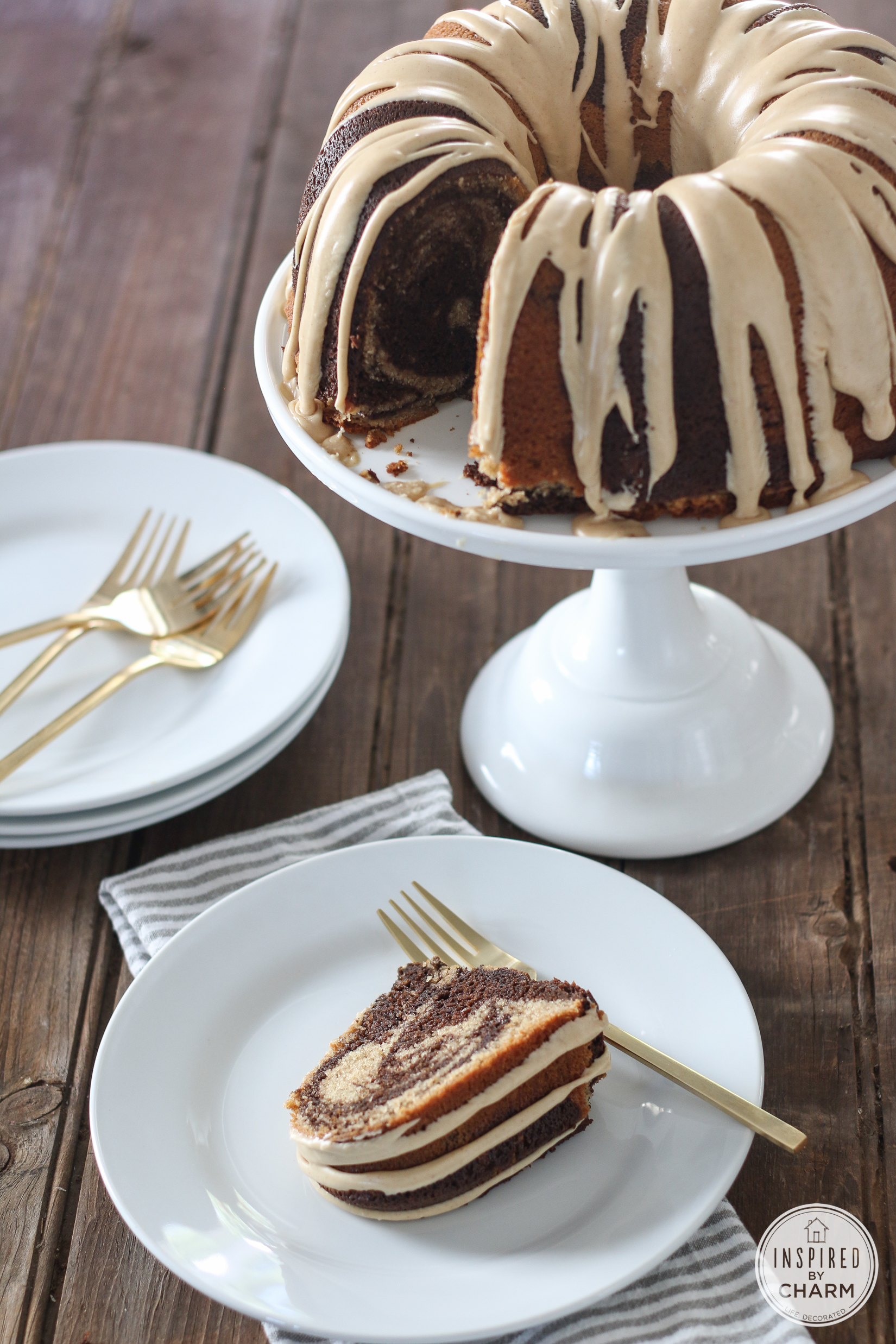slice of peanut butter chocolate cake served on a plate with large cake on a cake stand. 