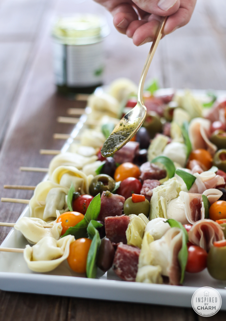 drizzling basil pesto of skewered meat, veggies, cheese and pasta