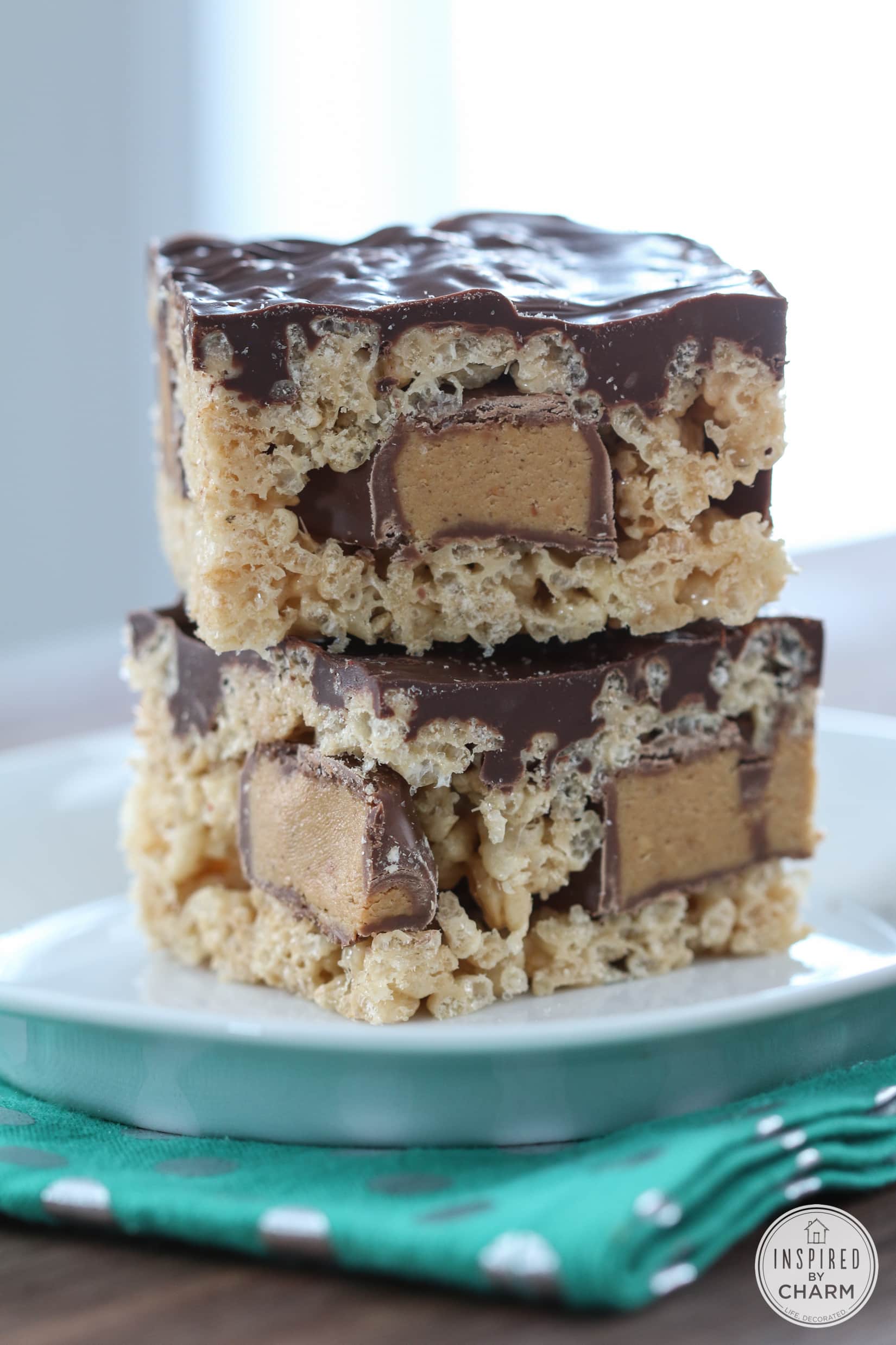 two Peanut Butter Cup Rice Krispies Treats stacked on a plate.