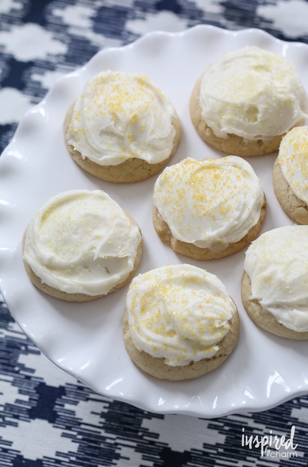 seven Soft Frosted Lemon Cookies on a cake stand.