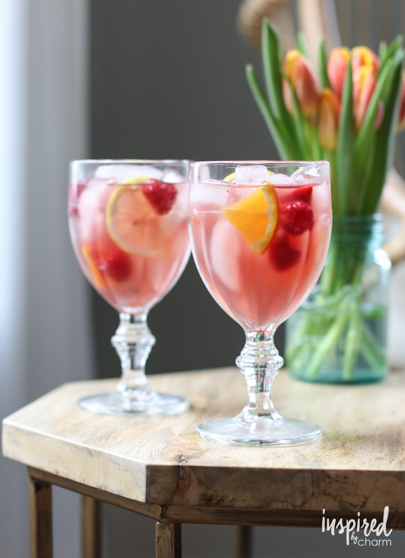 Rosé Sangria in two glasses with tulips in the background.
