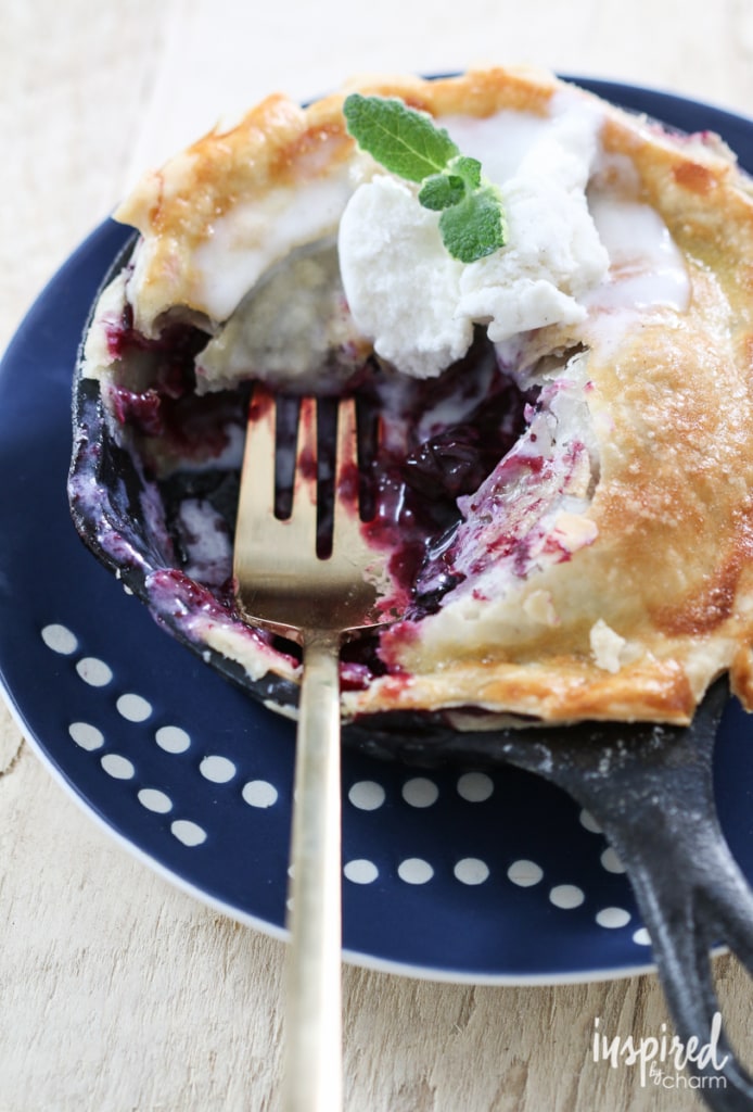 Mini Skillet Blueberry Pies with a fork on a plate.