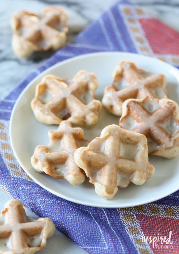 Cinnamon Waffle Cookies with Maple Glaze on a small plate on a colorful cloth napkin. 