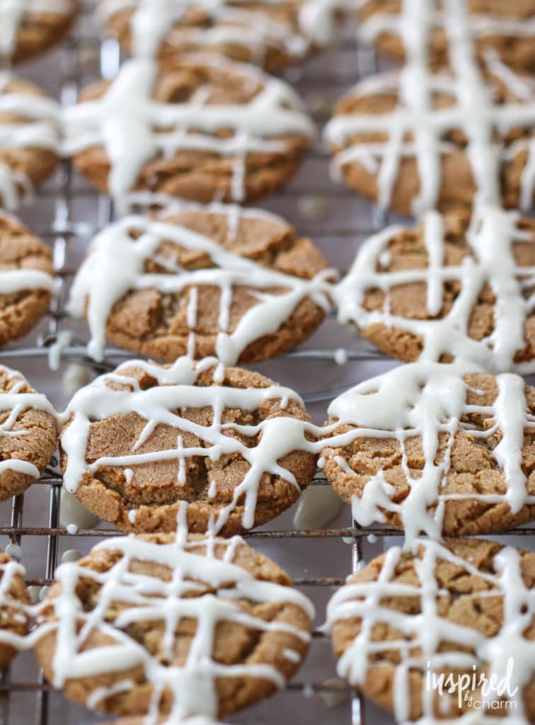 gingersnap cookies drizzled with apple cider glaze on a cooling rack. 