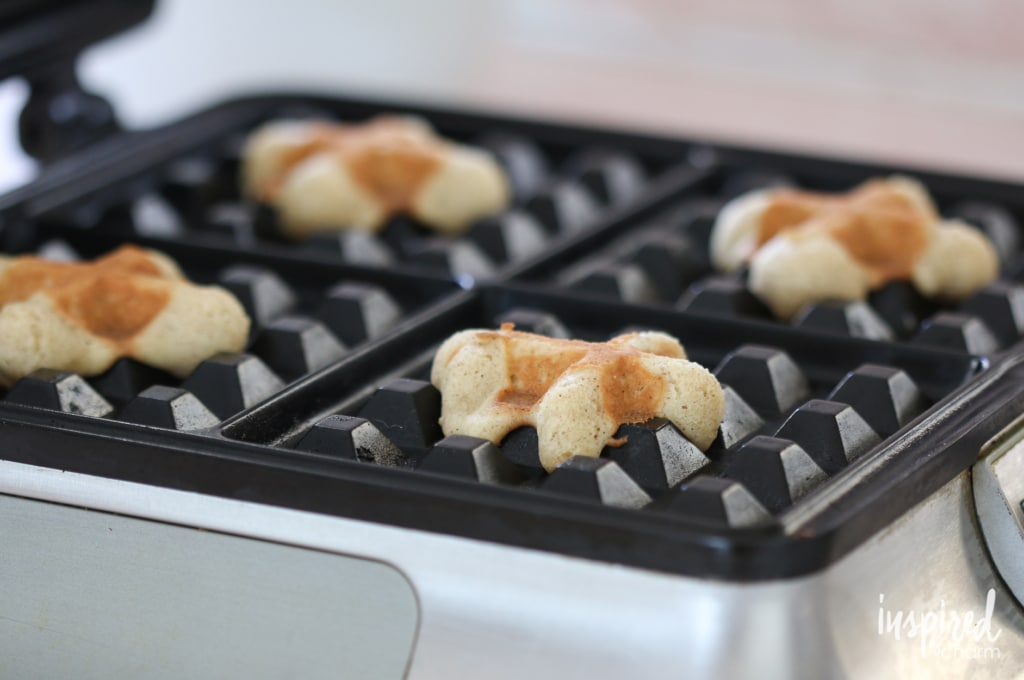 making waffle cookies on a waffle iron.