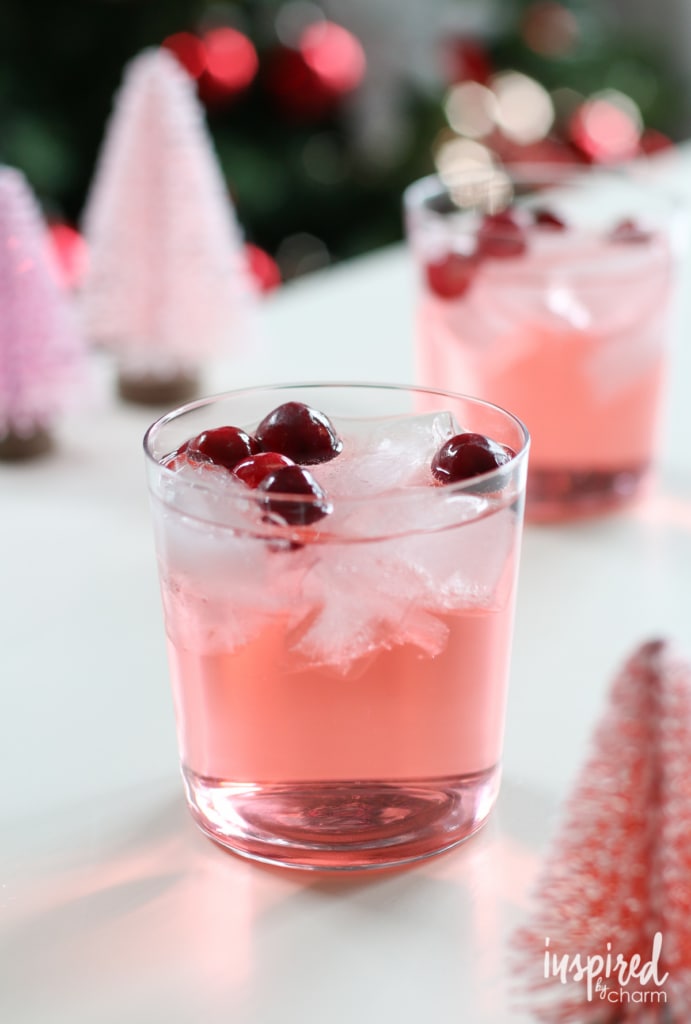 Glass of pink punch made with sparkling champagne, soda, and whipped vodka.