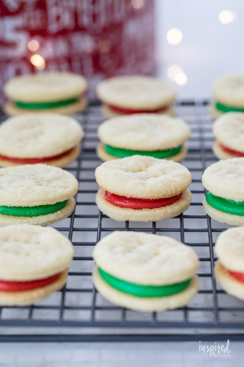 green and red filled cream wafer sandwich cookies on a cooling rack
