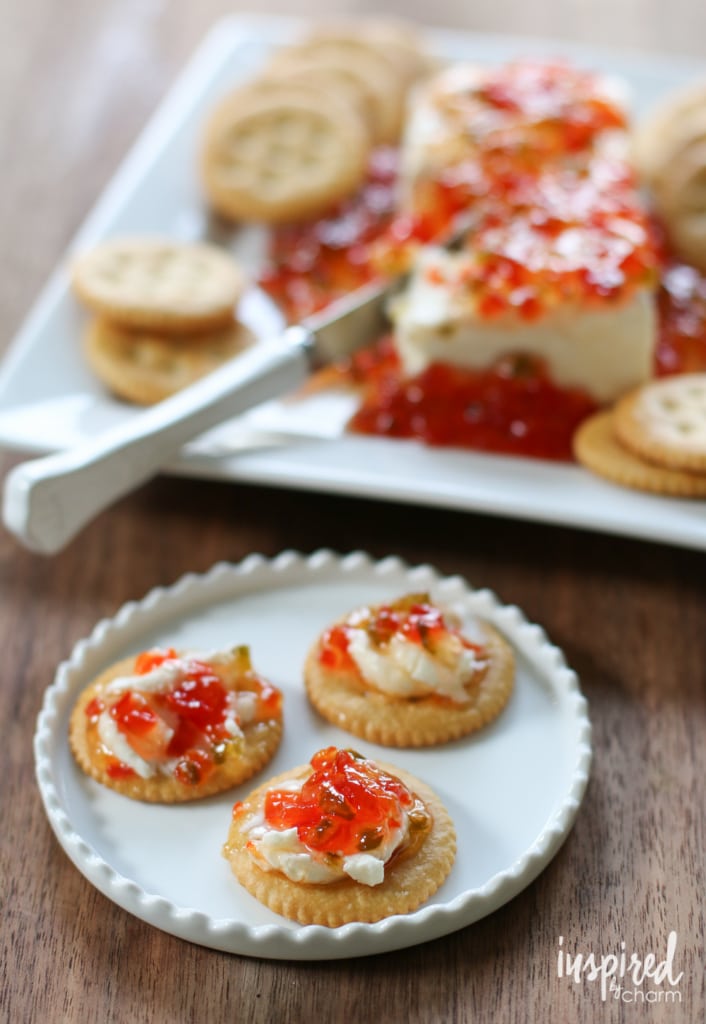 ritz crackers on a plate with cream cheese and pepper jelly on top