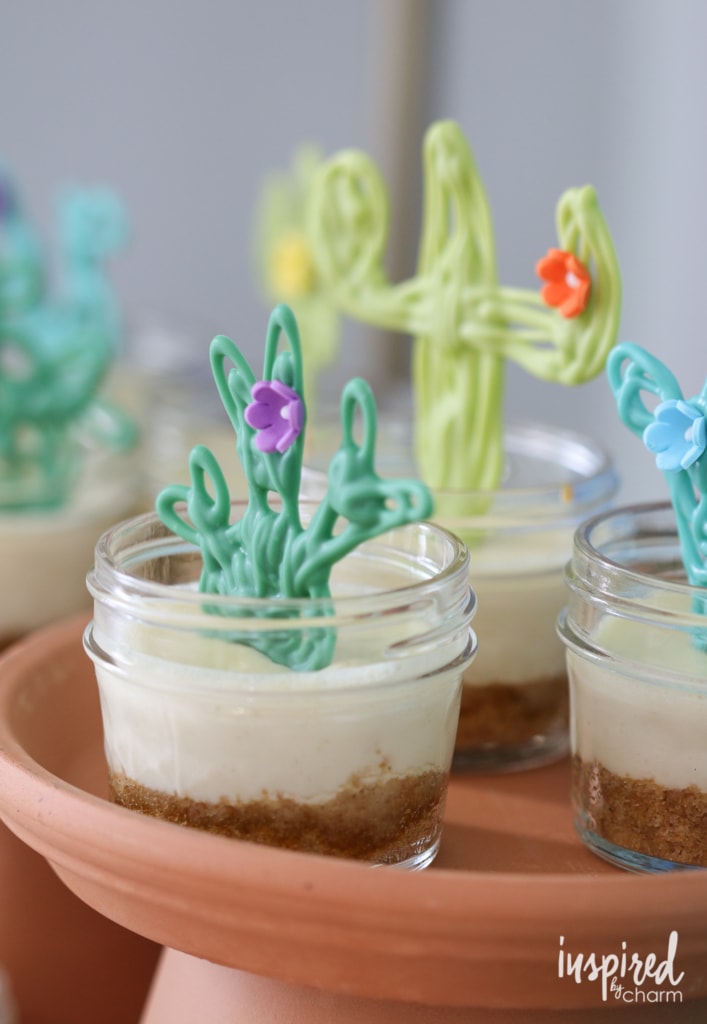 Mini Margarita Cheesecakes in small mason jars with chocolate cactus garnish.
