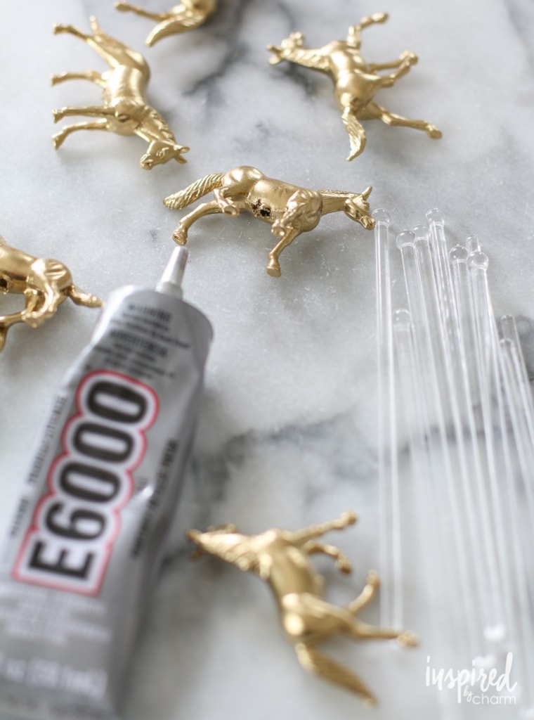 e6000 glue with  gold toy horses and clear drink stirrers.