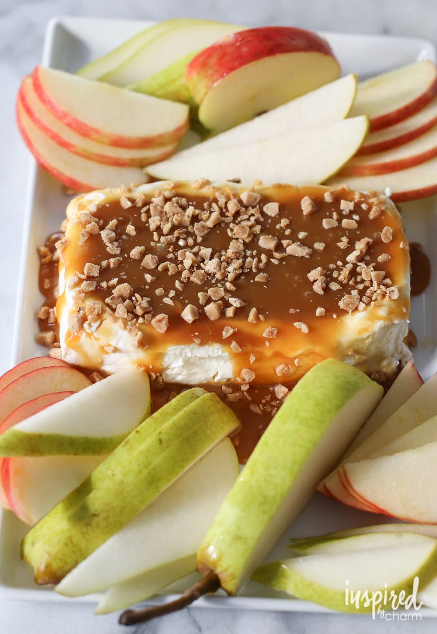 caramel apple cream cheese spread on a serving platter with sliced apples