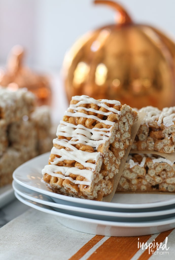 Butterscotch Pumpkin Cheerio Treat Bars on a stack of plates.