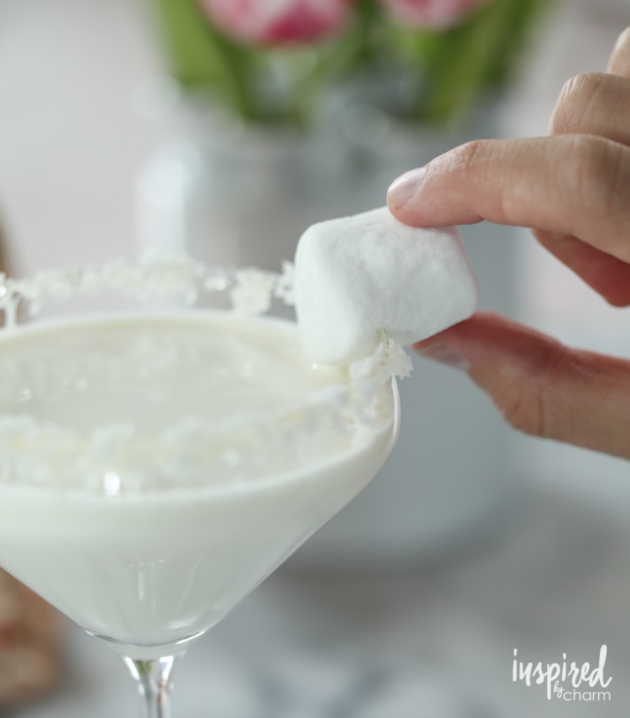 adding a marshmallow to the rim of a martini glass.