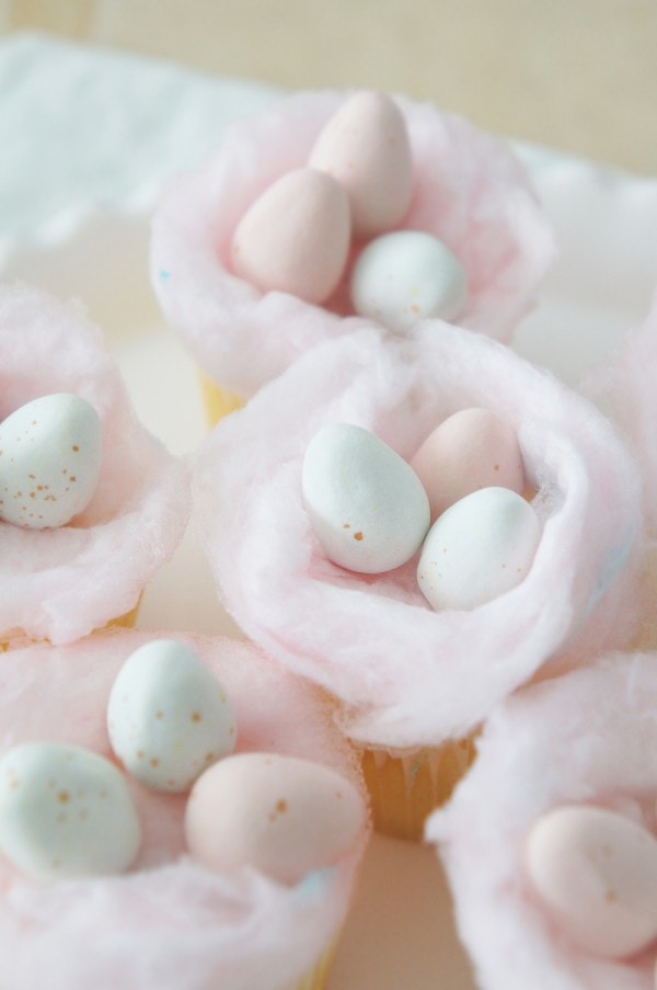 Cupcakes topped with cotton candy "nests" filled with candy eggs for easter