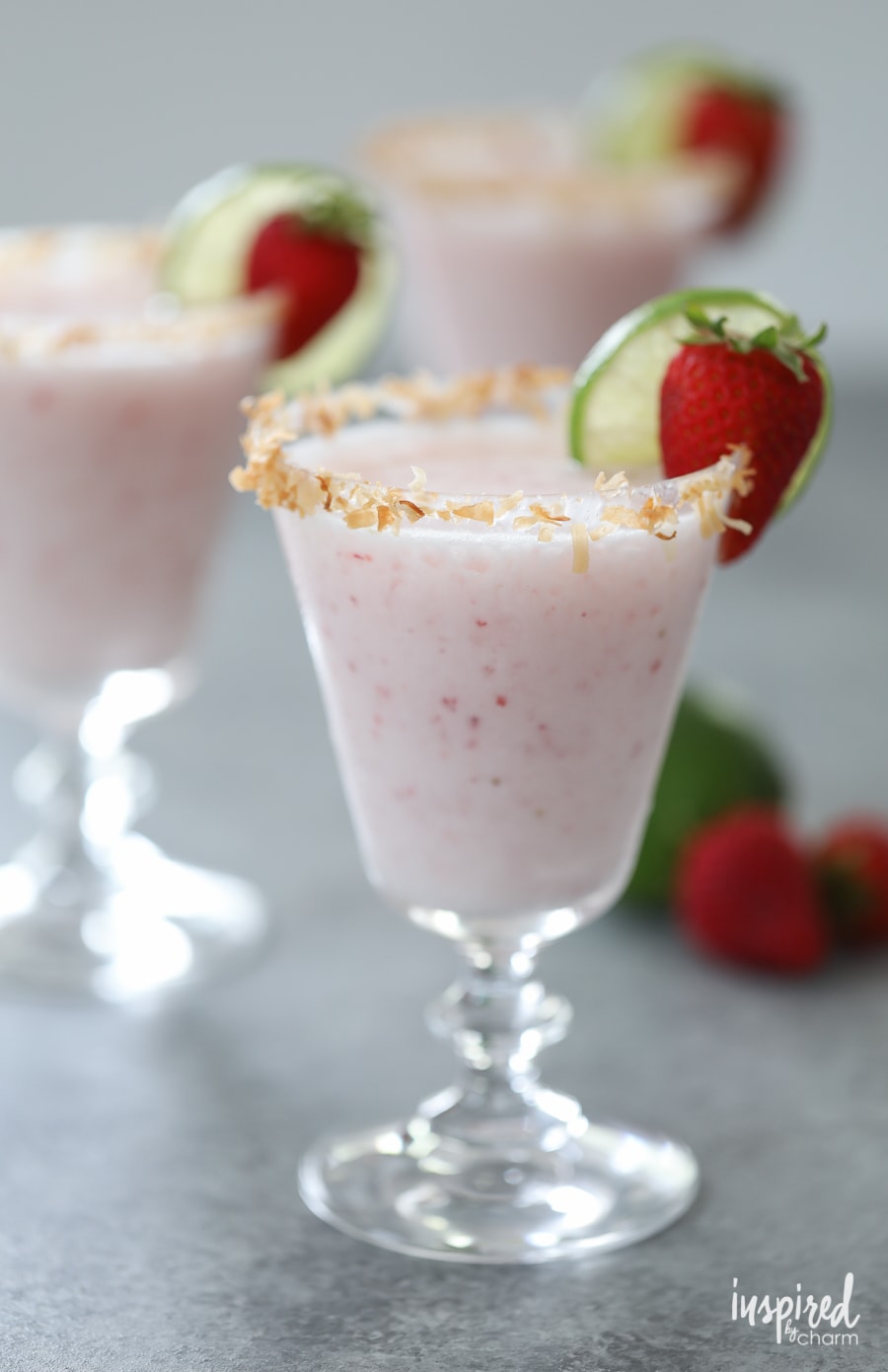 Strawberry Coconut Margarita in a glass with strawberry and lime garnish. 