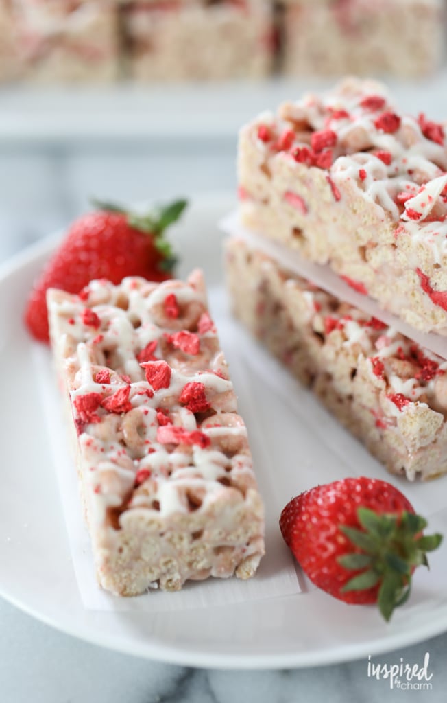 Strawberry Cheerio Treat Bars on a plate with strawberries.