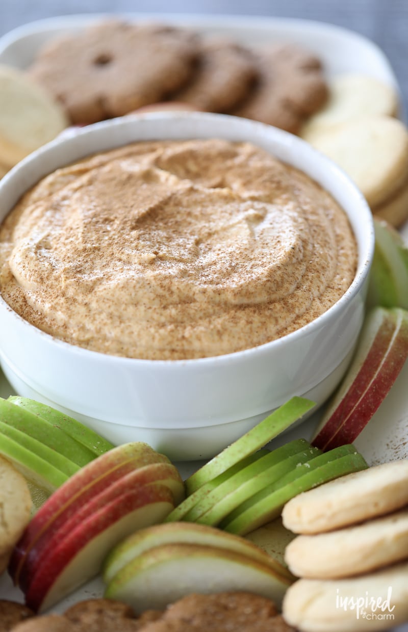 Delicious Pumpkin Spice Cheesecake Dip in a bowl with apple slices and cookies.