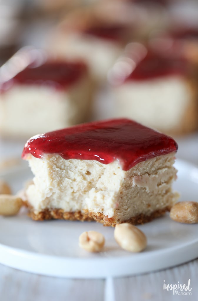 Peanut Butter and Jelly Cheesecake Bar on a small plate with peanuts.