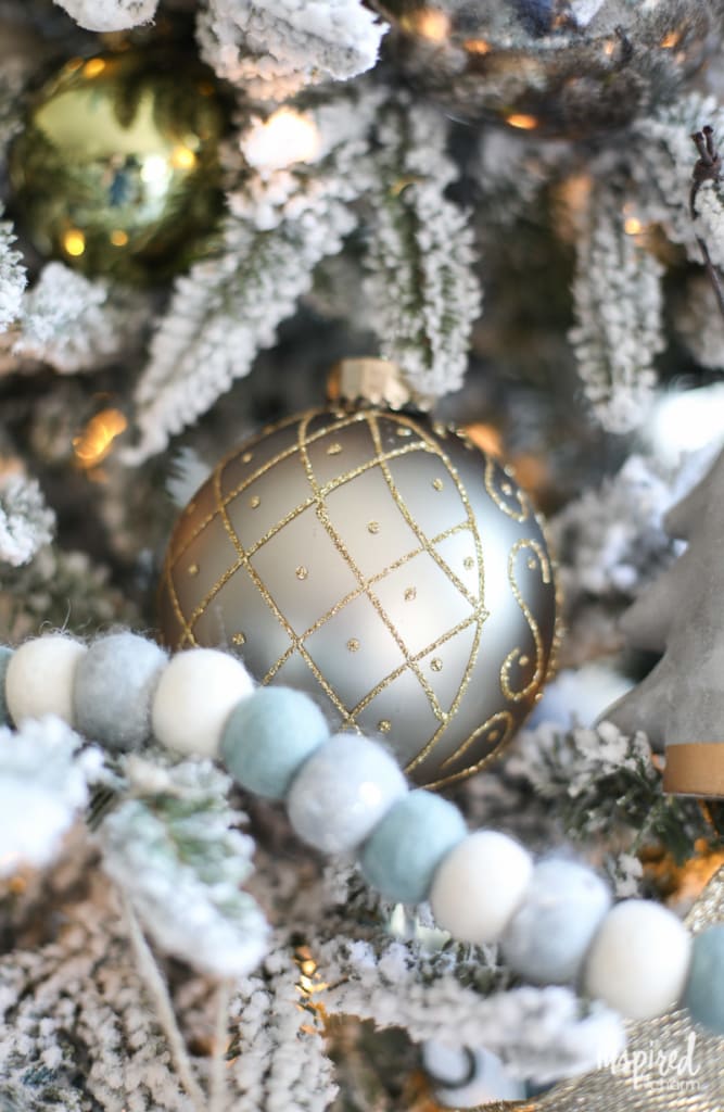 close up of gold bulb on flocked Christmas tree