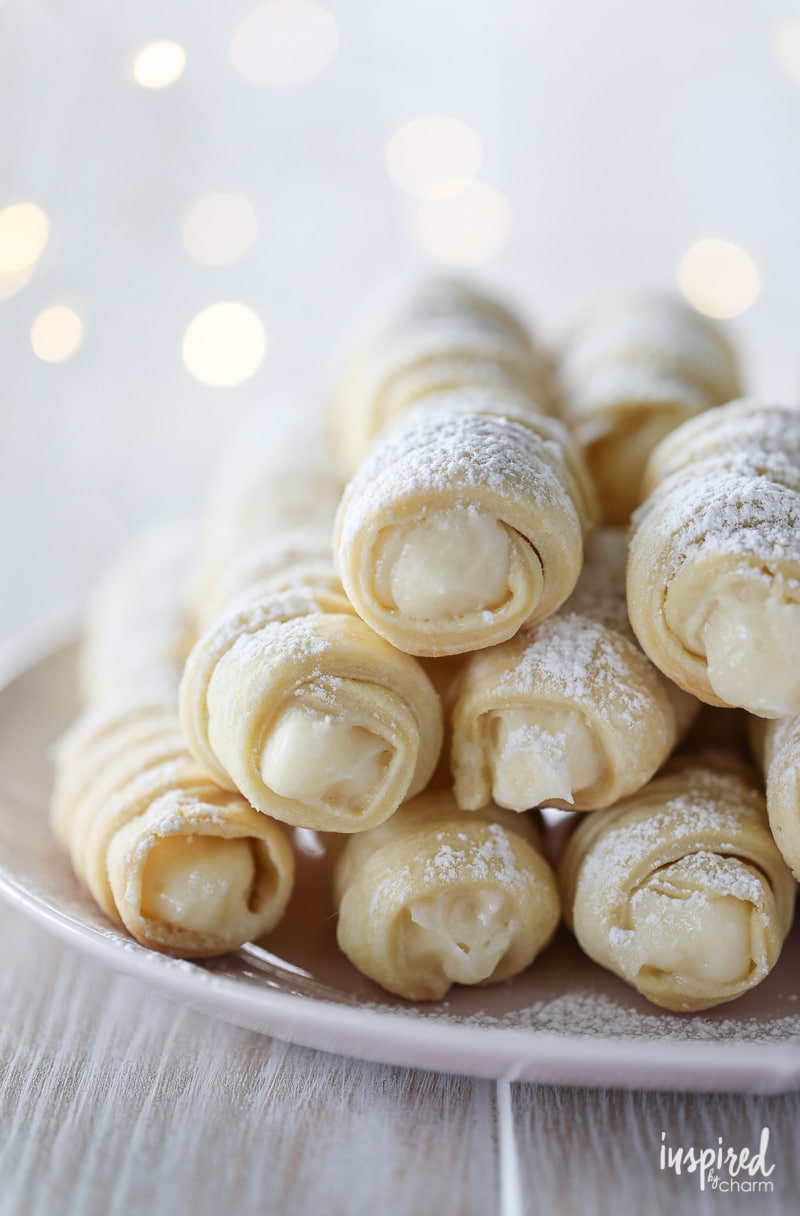 cream horns piled on a plate dusted with powdered sugar