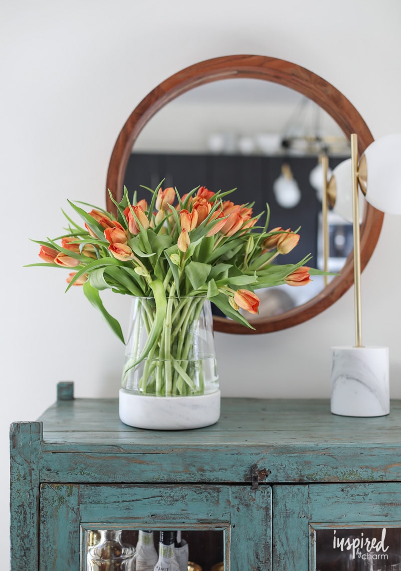 vase of tulips on a cabinet. 