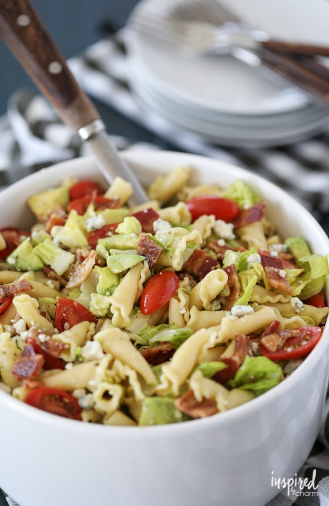 California Cobb Pasta Salad in a large white bowl with a spoon.