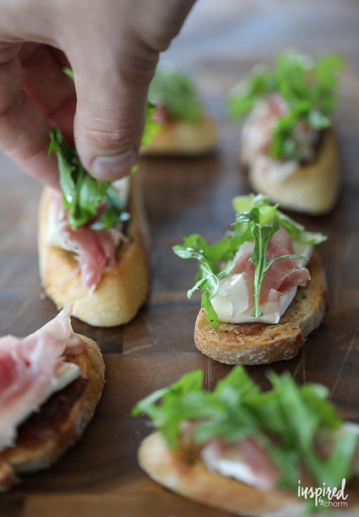 This Brie, Fig, and Prosciutto Crostini recipe makes a flavorful and easy appetizer. #appetizer #crostini #fig #arugula #brie #prosciutto 