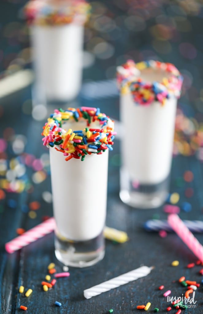 shot glass rimmed with sprinkles filled with a birthday cake flavored shot. 