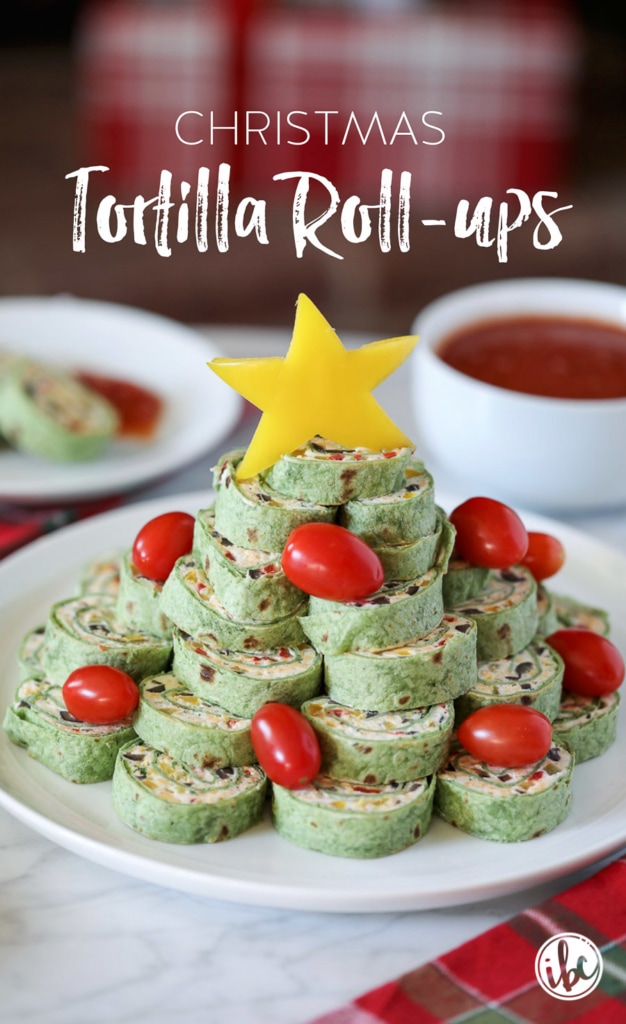 tortilla pinwheels stacked into a tree with cherry tomato ornaments and yellow pepper star.
