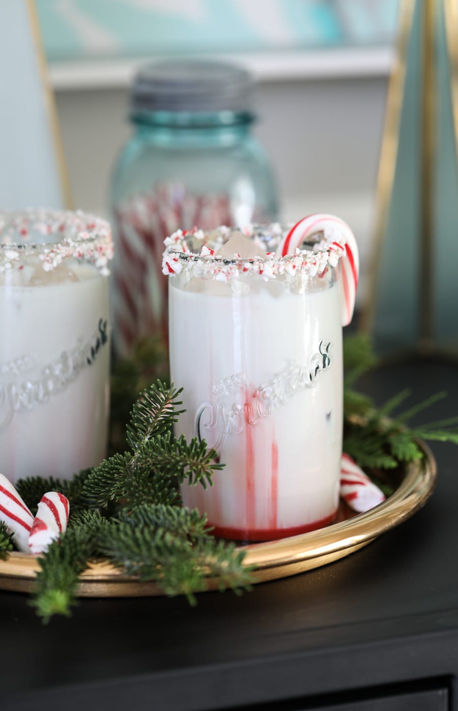 Peppermint White Russian Christmas cocktail in glass with candy cane garnish.