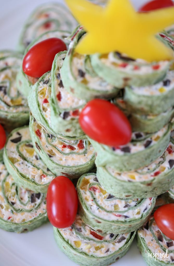 tortilla pinwheels stacked up with cherry tomatoes.