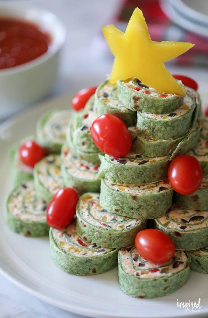 Christmas Tortilla Pinwheels served on a plate with cherry tomatoes and yellow pepper star.