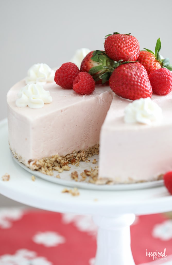 Strawberry Ice Cream Cheesecake on cake stand.