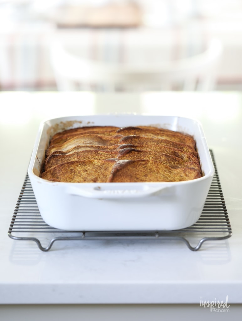 baked pumpkin french toast casserole in a white baking dish.
