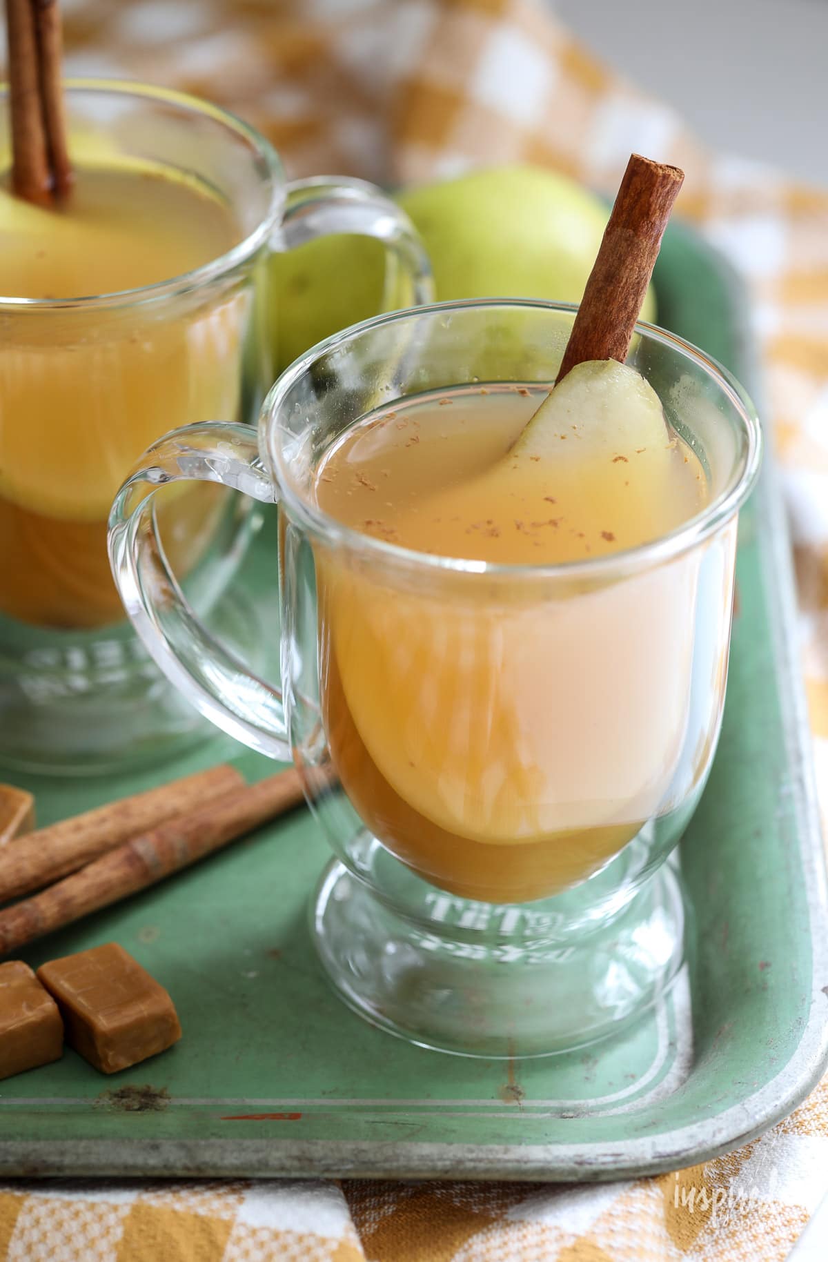 Caramel Pear Cider in glass with cinnamon stick. 