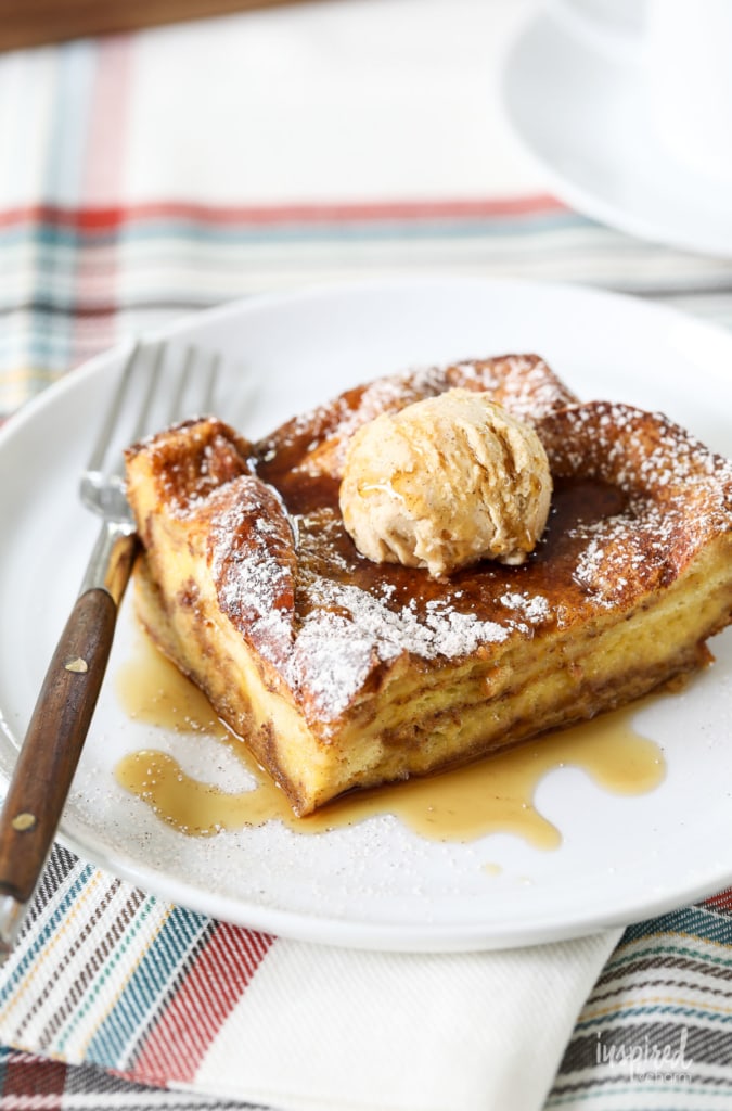pumpkin french toast casserole topped with butter and maple syrup served on a plate with a fork.