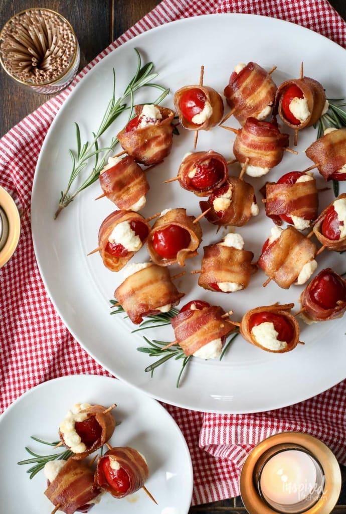 Bacon-Wrapped Stuffed Peppadew Peppers on a plate with toothpicks.