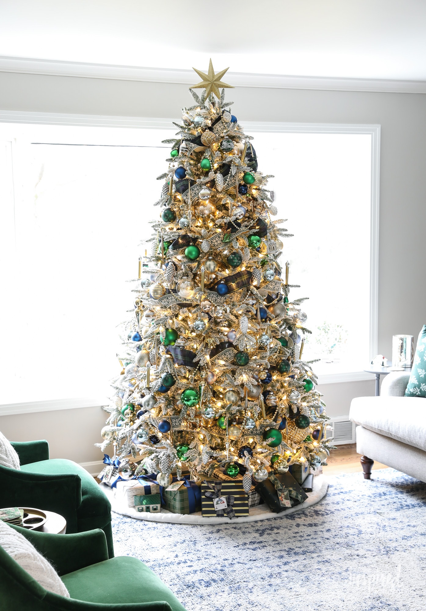christmas tree decorated with metallic, greens, and navy ornaments. 