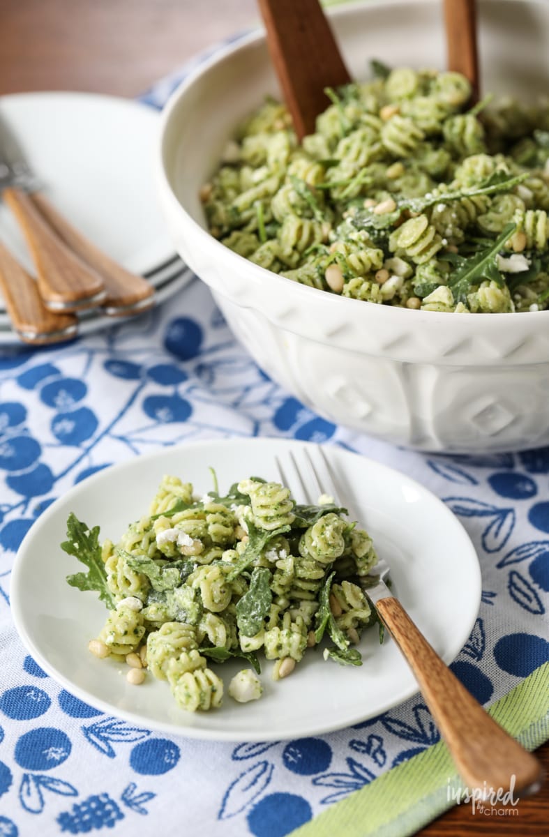 Pine Nut and Arugula Pesto Pasta Salad in a big bowl and served on a small plate.