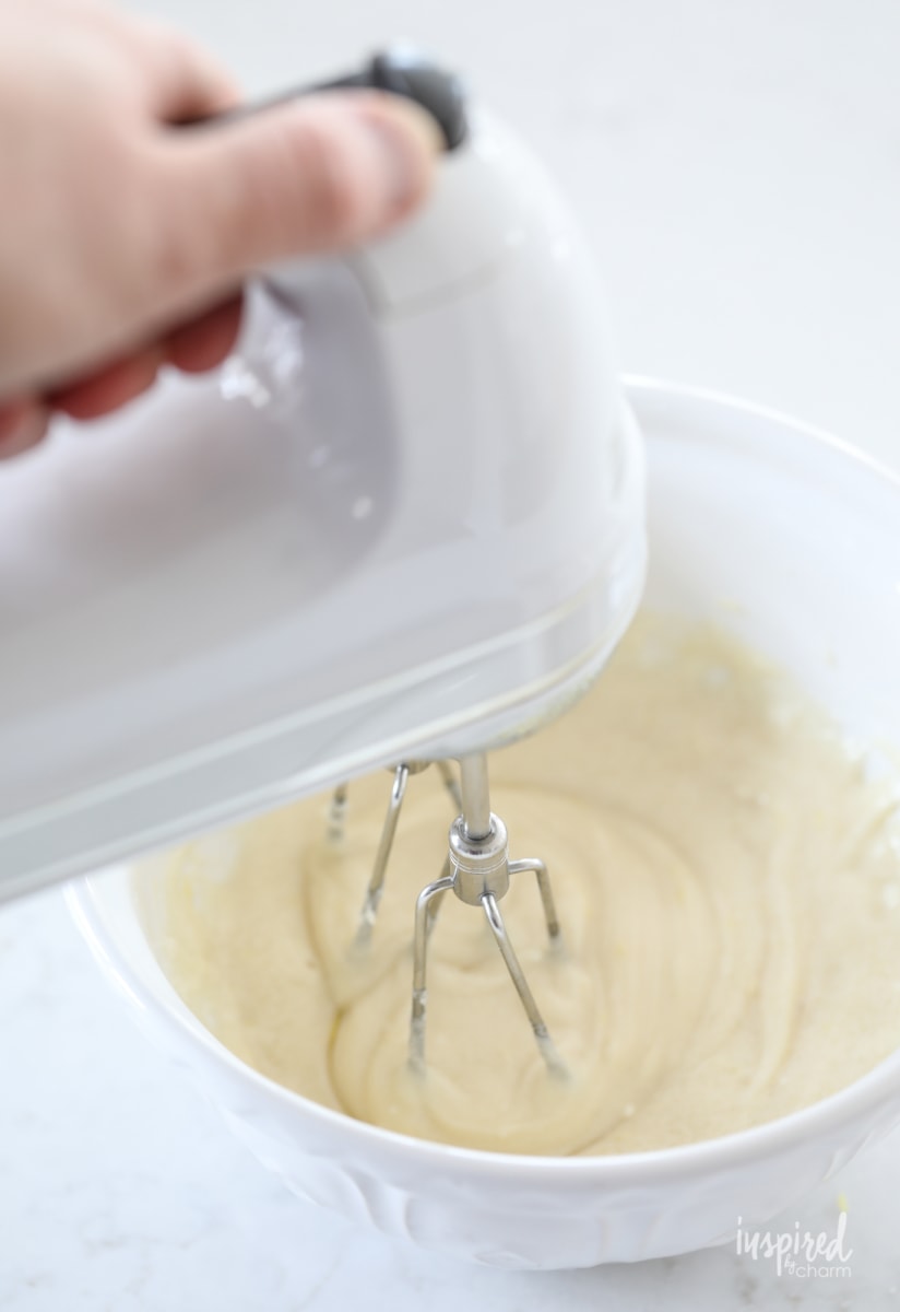 mixing cheesecake with a hand mixer. 
