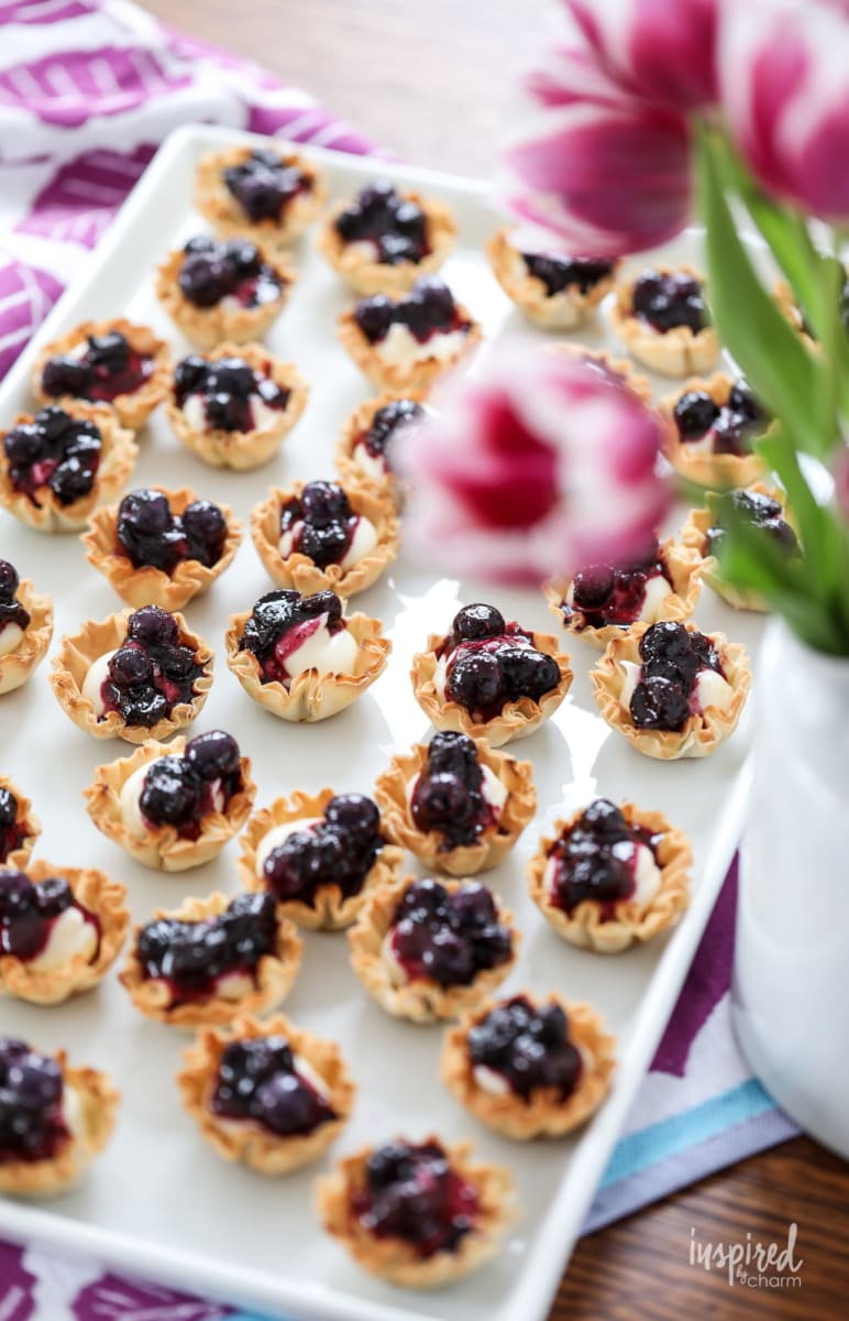 mini blueberry cheesecakes bites on a large platter.