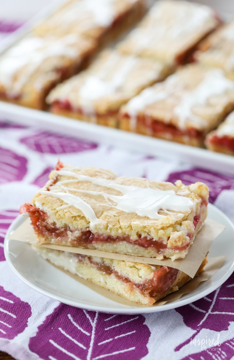 Strawberry Rhubarb Pie Bars stacked on a plate.