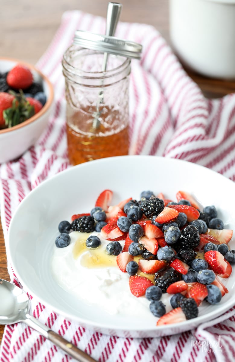 bowl with yogurt, mixed berries, and honey.