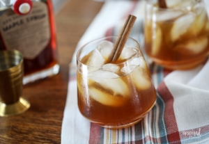 Cider and Maple Old Fashioned in a class with a cinnamon stick garnish.