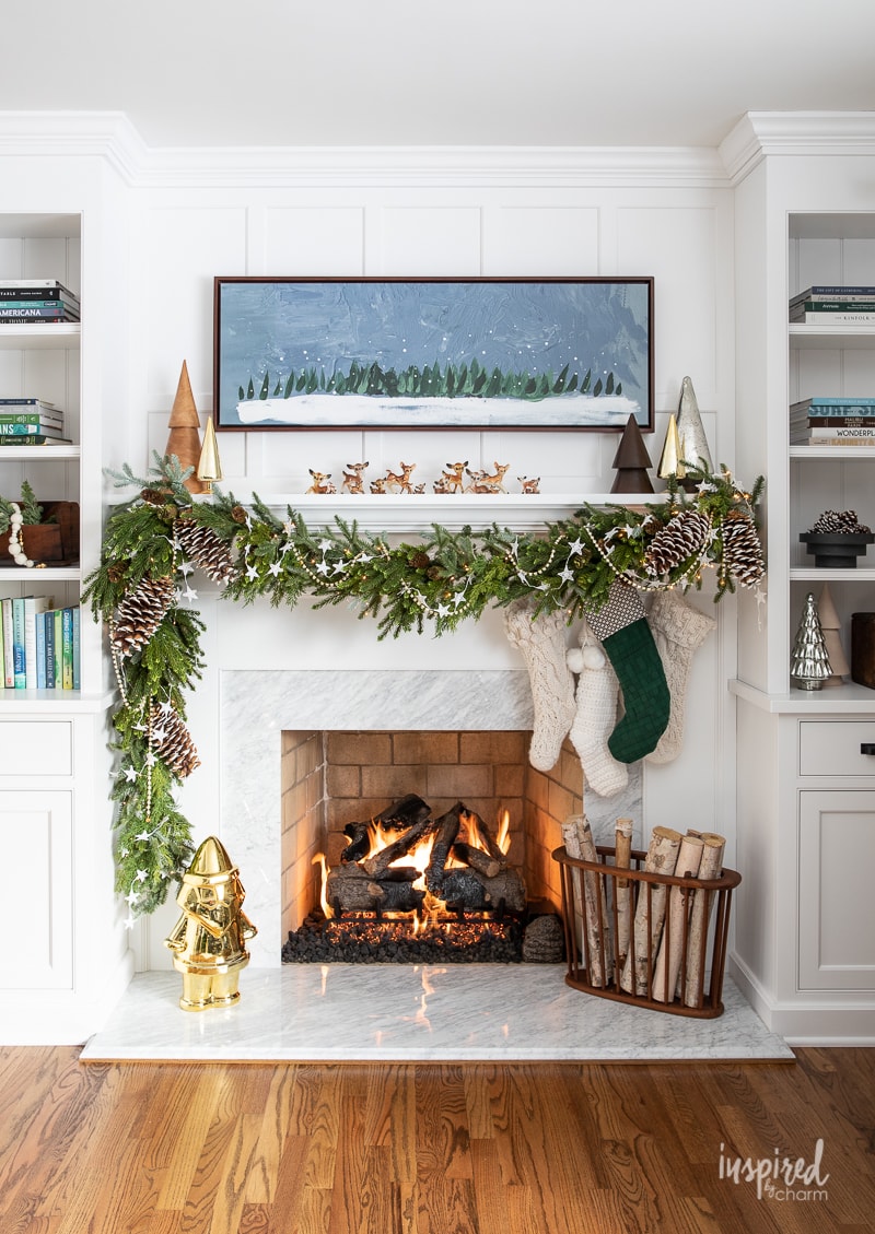 a white fireplace mantel with simple green and white decor